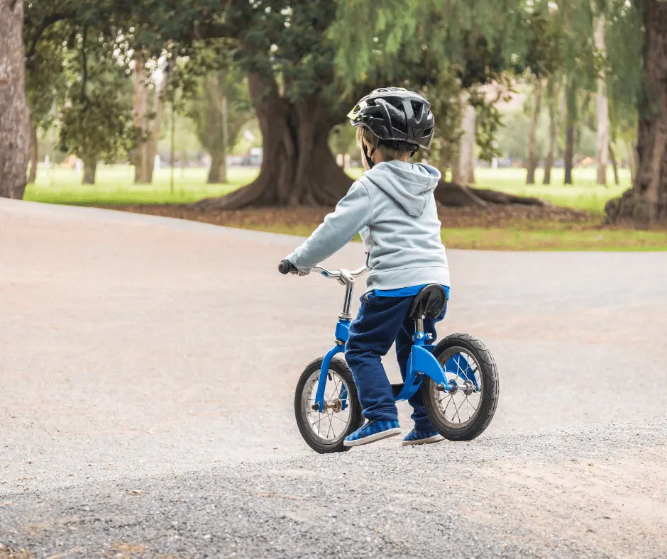 Young child on bike looking ahead at bike trail